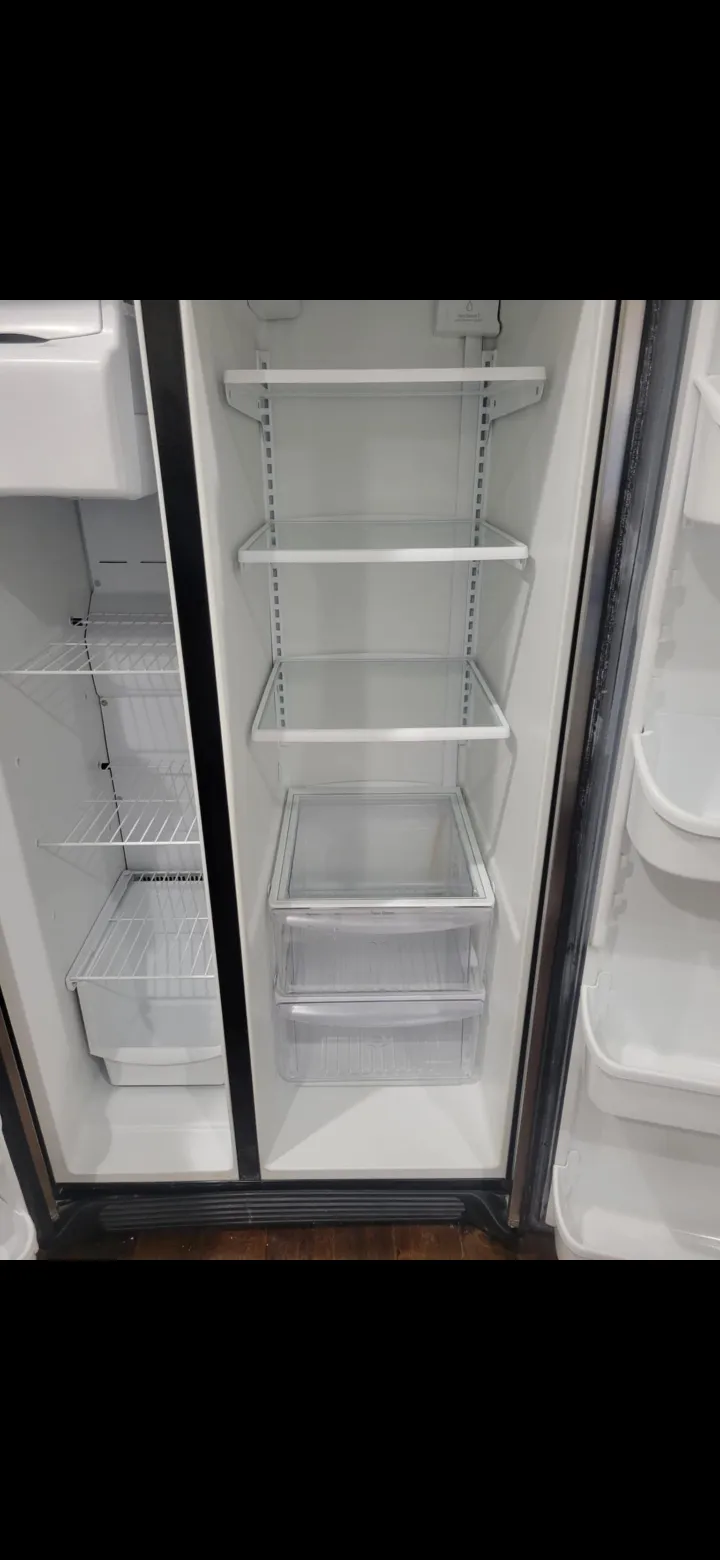 The inside of a refrigerator cleaned by Happy Maids, shelves and bins empty and wiped